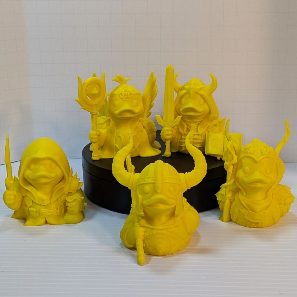 A collection of yellow 3D printed ducks dressed like fantasy characters.