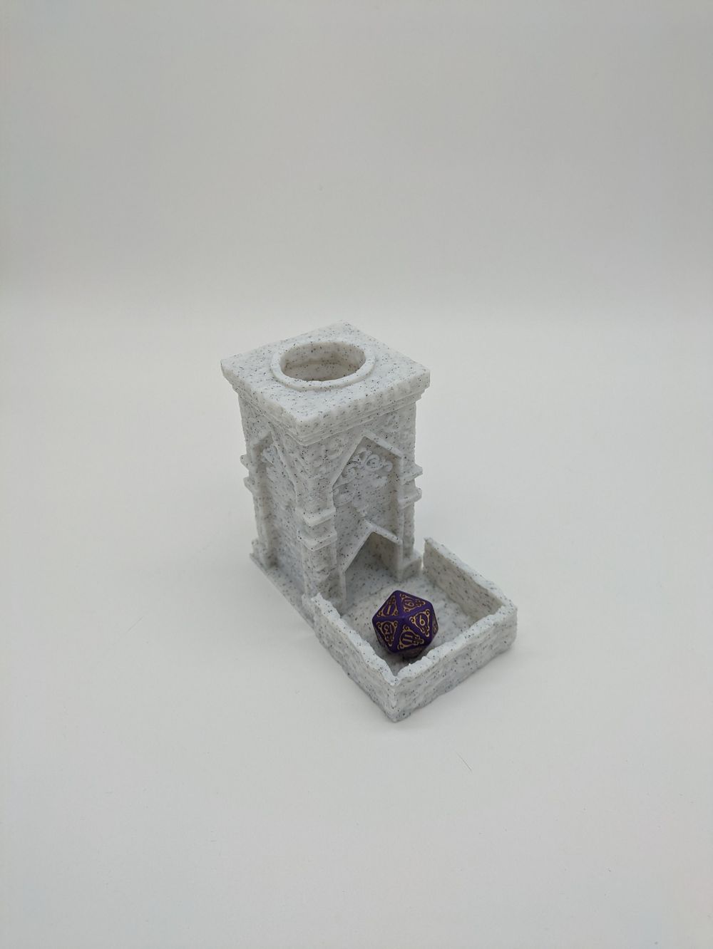 A smaller 3D printed dice tower. It looks like a square, flat roofed tower, and it's printed in a marble-like filament.