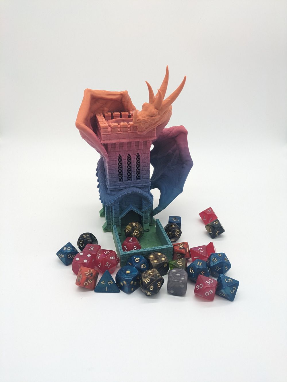 A 3D printed dice tower, printed in a dark rainbow filament. The tower is small, with what looks like a stone castle tower that has a wyvern wrapped around it. The base is surrounded by colorful dice.